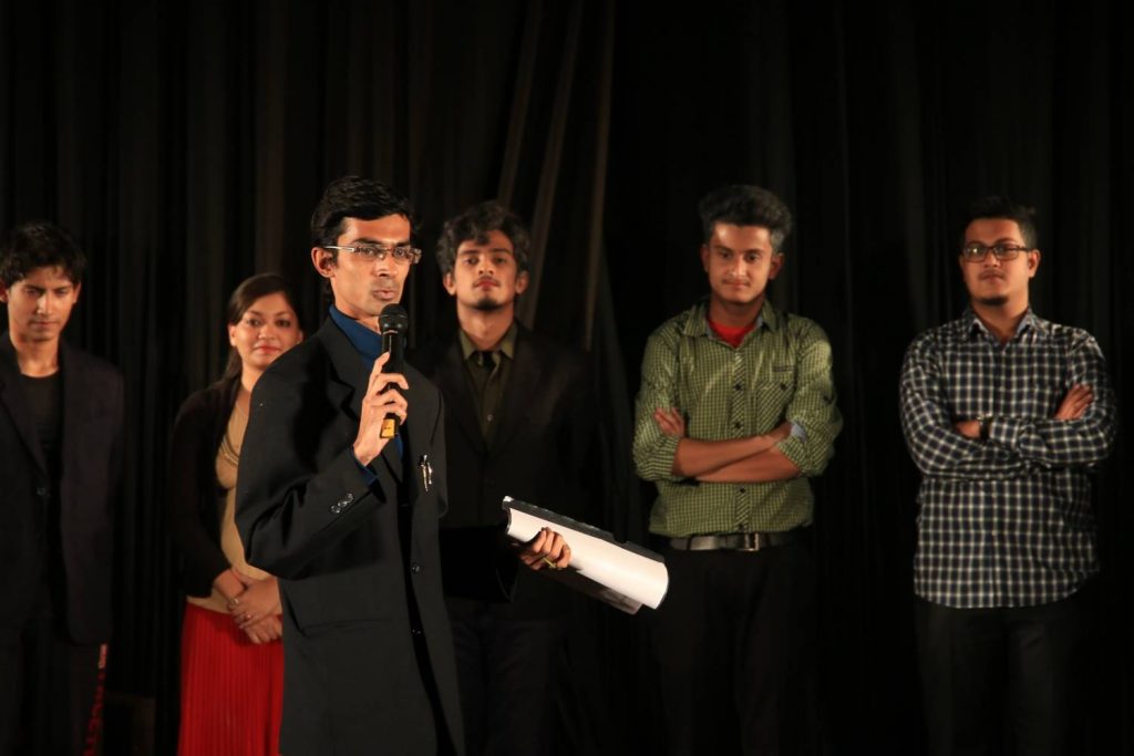 Director, Dr. Nilanko Mallik, addresses the audience after the show, with actors looking on.