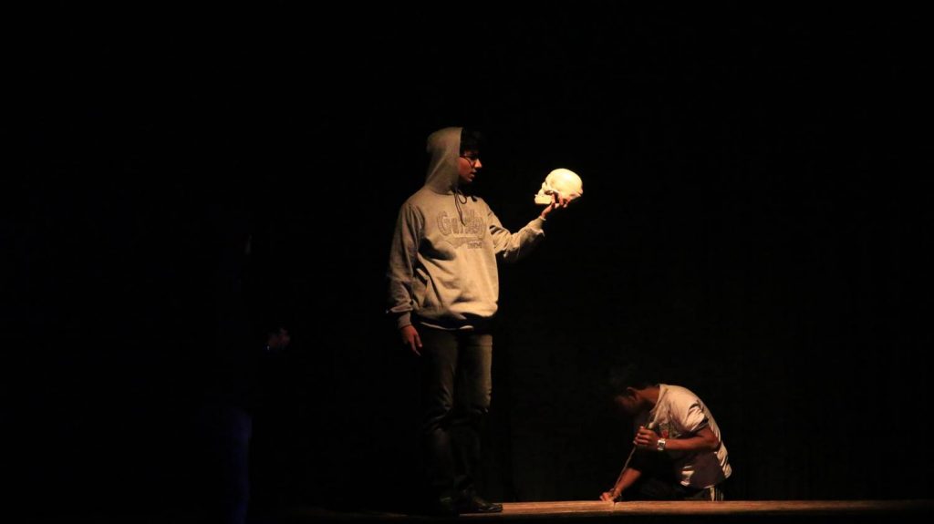 Ophelia's funeral scene, with a Gravedigger and Hamlet holding a skull.